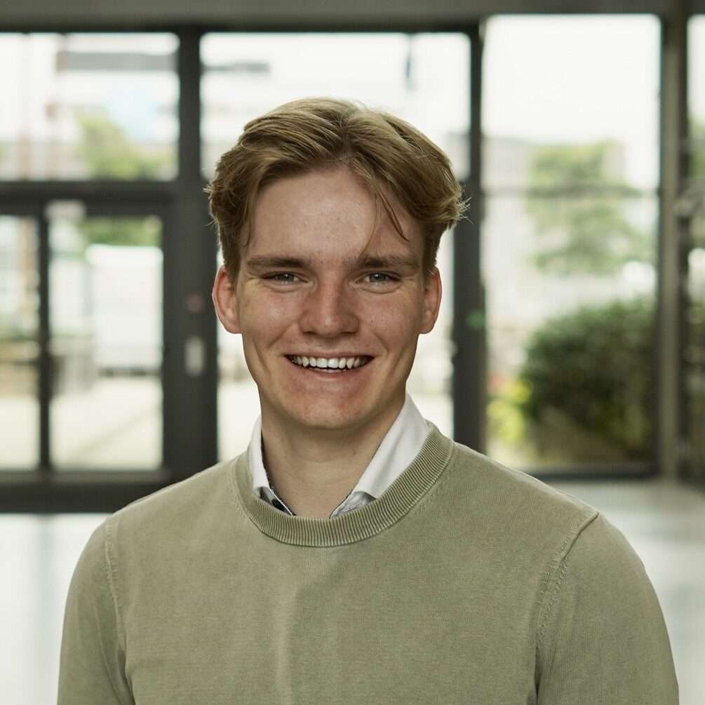 Headshot picture of a smiling white blonde male with blue eyes for About.