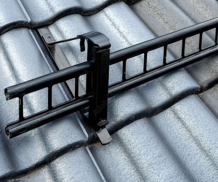 A black composite roof guard on a concrete roof.